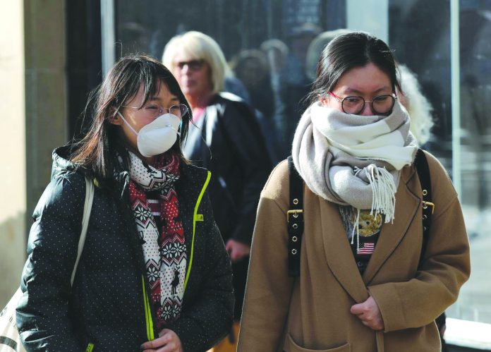 Coronavirus Britain A pedestrian wearing a protective face mask walks in Princes Street in Edinburgh, Scotland, Britain on March 4. REUTERS/RUSSELL CHEYNE/FILE PHOTO