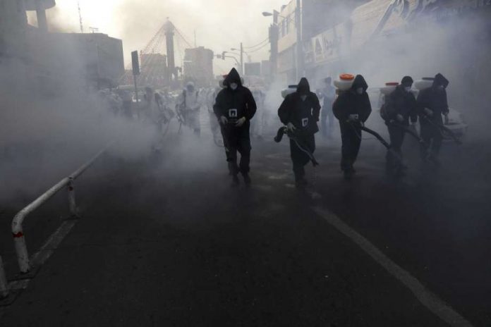 Firefighters disinfect a street Firefighters disinfect a street against the new coronavirus, in western Tehran, Iran, Friday, March 13, 2020. AP