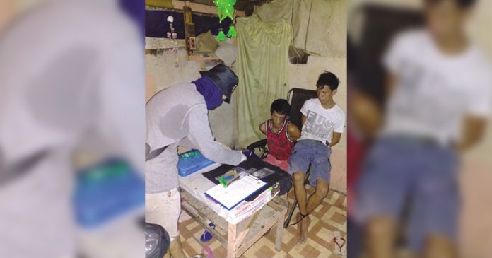 An antidrug officer inspect items seized from brothers Jan Mark and Raymart Dela Cruz, who were nabbed in a buy-bust operation in their residence in Barangay 2, Bacolod City on March 20. POLICE STATION 2/BCPO