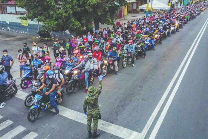 Long line of motorists and pedestrians at the border of Muntinlupa and San Pedro, Manila Long line of motorists and pedestrians at the border of Muntinlupa and San Pedro, Manila on Tuesday as authorities begin implementing an “enhanced community quarantine” over the entire island of Luzon. EZRA ACAYAN/ GETTY IMAGES