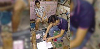 An antidrug officer inspects items seized from Mark Lawrence Onggada, who was nabbed in a buy-bust operation in Barangay 3, Bacolod City on March 19. POLICE STATION 2/ BCPO