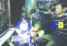 Antidrug officers inspect items seized from Michael Mercado. He was nabbed in an entrapment operation in Barangay 2, Bacolod City on March 1. POLICE STATION 2/BCPO