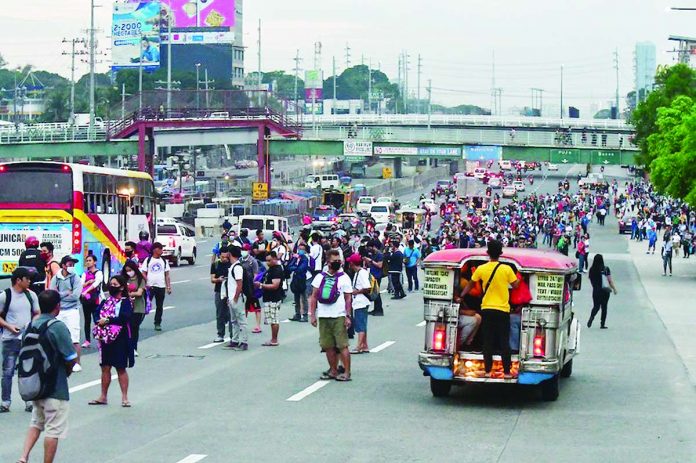 Commuters scramble for a ride at the southbound lane of Commonwealth Avenue in Quezon City on Monday Commuters scramble for a ride at the southbound lane of Commonwealth Avenue in Quezon City on Monday, the 1st work day in Metro Manila after the imposition of a "community quarantine" that will last until April 14. Thousands of workers are expected to cross the border of the region as authorities moved to halt the spread of coronavirus disease 2019. ABS-CBN NEWS