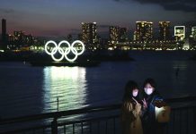 Worldwide athletes group calls to delay Olympics Two women take a selfie with the Olympic rings in the background in the Odaiba section of Tokyo, Thursday, March 12, 2020. AP