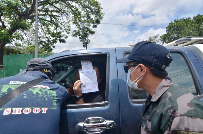 QUARANTINE CHECK. Police officers check a motorist’s credentials at a quarantine control point in Barangay Ungka, Jaro, Iloilo City. The metro is under an enhanced community quarantine to contain the spread of the coronavirus disease 2019. IAN PAUL CORDERO/PN