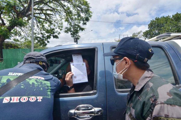 QUARANTINE CHECK QUARANTINE CHECK. Police officers check a motorist’s credentials at a quarantine control point in Barangay Ungka, Jaro, Iloilo City. The metro is under an enhanced community quarantine to contain the spread of the coronavirus disease 2019. IAN PAUL CORDERO/PN