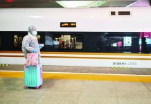 China virus epicenter eases travel restrictions A woman wearing protective gear as she boards a train stopping at Wuhan, which has opened stations again to incoming passengers. AFP