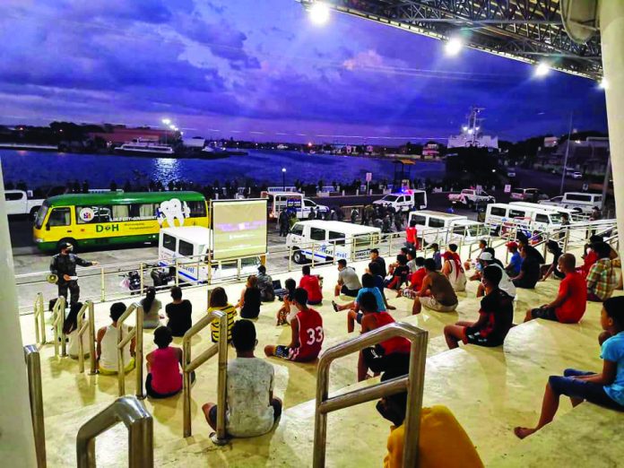 Personnel of the Iloilo City Police Office (ICPO) gather these individuals who defied quarantine rules at the Iloilo Freedom Grandstand for a film showing about coronavirus disease 2019. ICPO began to implement this strategy to warn violators of the consequences of not abiding by the government's measures to prevent the spread of the disease. ICPO