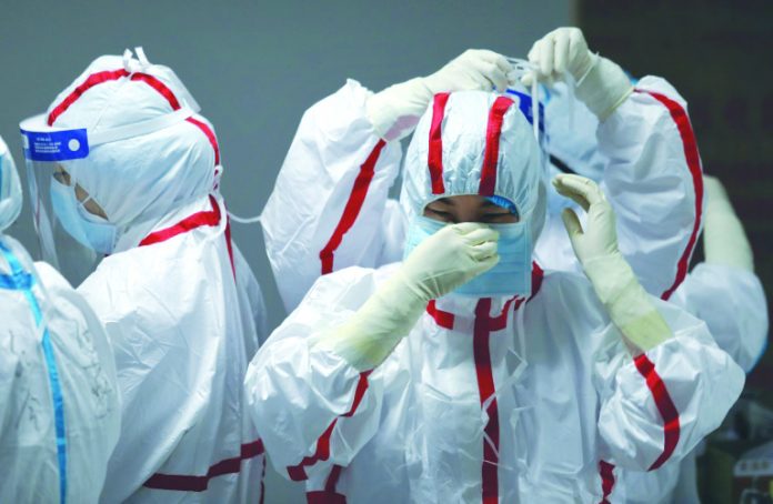 Medical staff put on protective equipment Medical staff put on protective equipment before attending to COVID-19 patients at the Red Cross Hospital in Wuhan in China's central Hubei province on March 16, 2020. AFP