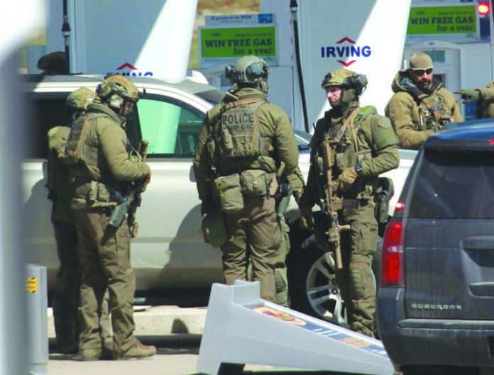 Royal Canadian Mounted Police Members of a Royal Canadian Mounted Police tactical unit confer after a suspect in a deadly shooting rampage was neutralized at the Big Stop near Elmsdale, Nova Scotiam, Canada. AFP
