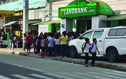 Beneficiaries of the Pantawid Pamilyang Pilipino Program wait outside a bank Beneficiaries of the Pantawid Pamilyang Pilipino Program wait outside a bank in this province before withdrawing their cash grant. PNA