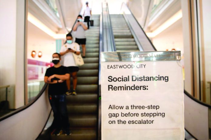 A poster reminding shoppers to maintain social distance in a shopping mall in Quezon City, Metro Manila, Philippines