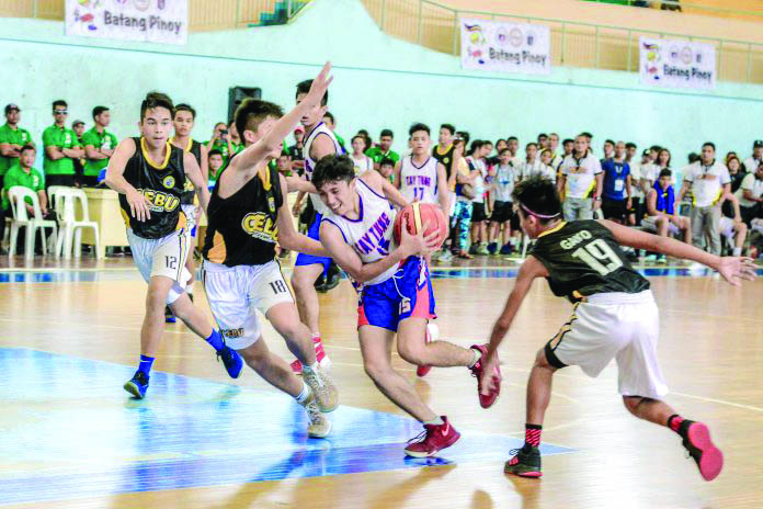 Bacolod Tay Tung High School’s Nathan Jundana attempts to score on the paint against Cebu City defenders Bacolod Tay Tung High School’s Nathan Jundana attempts to score on the paint against Cebu City defenders during the Visayas qualifier of the 2019 Philippine Youth Games-Batang Pinoy (PYG-BP) in Iloilo City. The Philippine Sports Commission cancelled this year’s edition of the PYG-BP and the Philippine National Games due to the ongoing scare of coronavirus disease 2019. IAN PAUL CORDERO