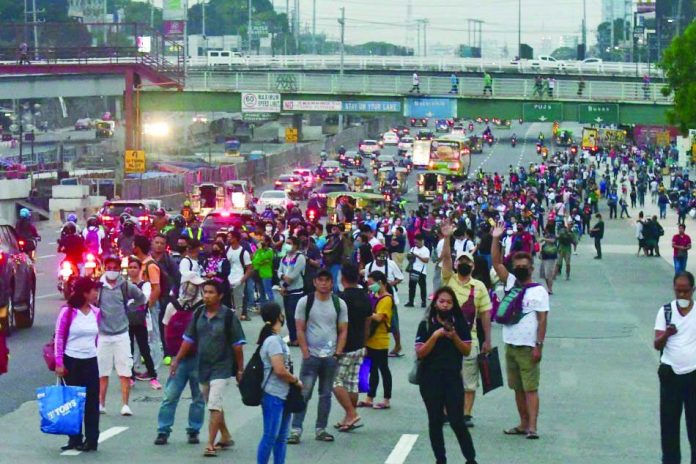 Commuters fill parts of the southbound lane of Commonwealth Avenue on the second day of the Metro Manila community quarantine on March 16, 2020.