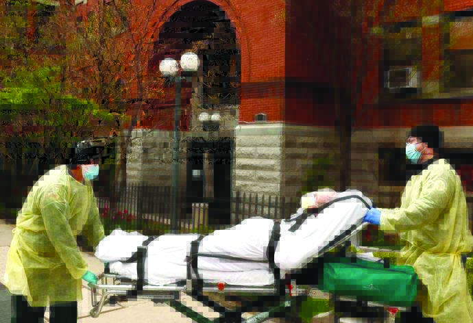 Emergency Medical Technicians wheel a man out of the Cobble Hill Health Center nursing home