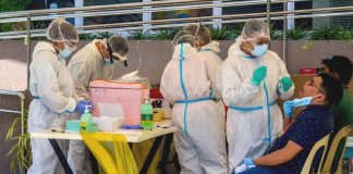 Fully covered with personal protective equipment, these healthcare personnel of the Iloilo City government are tasked to extract specimens from clients for analysis at the Western Visayas Medical Center laboratory. The city government is ramping up mass testing for coronavirus disease. IAN PAUL CORDERO/PN