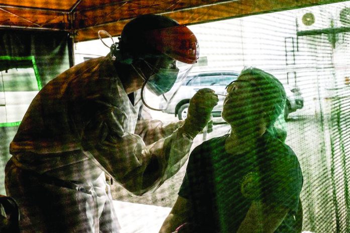 Healthworkers conduct their routine swab testing for COVID-19