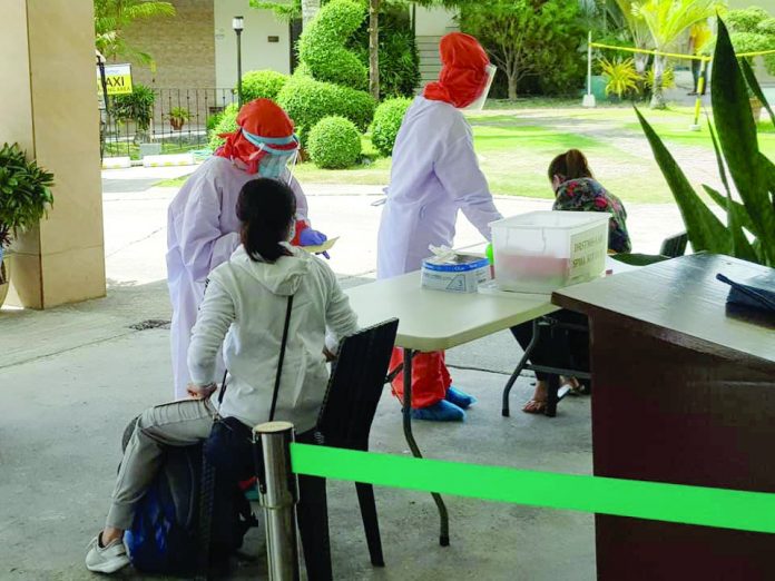 Medical personnel inspect the health conditions of the repatriated Aklanon overseas Filipino workers (OFWs) at a hotel in Kalibo, Aklan.