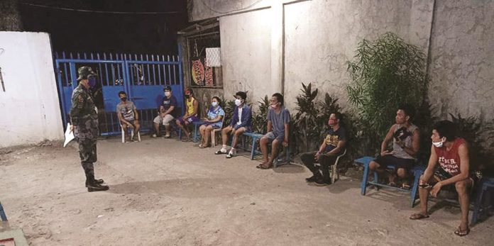 This police personnel orients violators of the rules of the general community quarantine in Bacolod City.