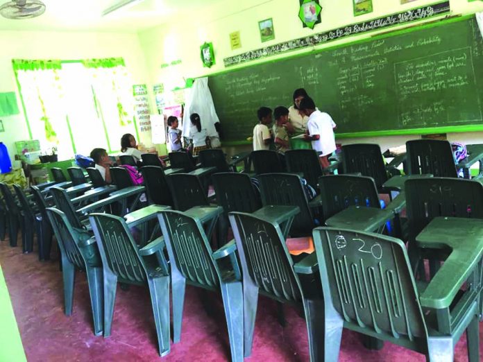 A teacher in Magtulis Elementary School in Barbaza, Antique discusses with her students during a class.