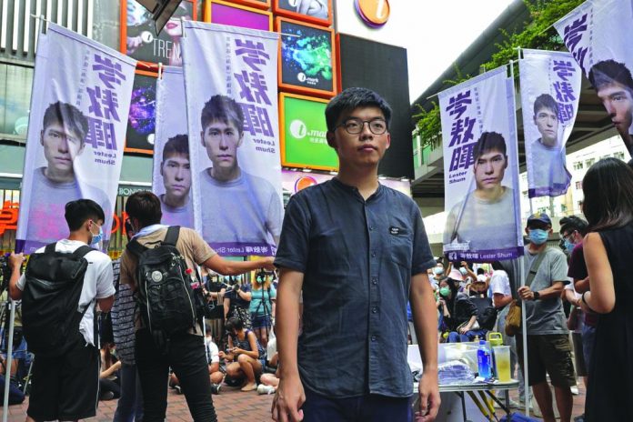 Hong Kong activist Joshua Wong poses for a photo after an interview as he attends an activity for the upcoming Legislative Council elections in Hong Kong Saturday, June 20, 2020.