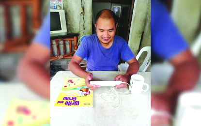 Joel Sermeno enrolls his nephew at the Sibalom Central School through online on Monday.