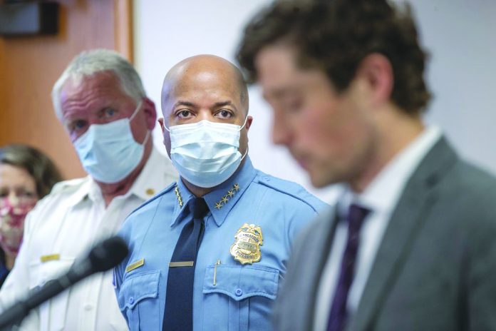 Minneapolis Police Chief Medaria Arradondo, center, listens as Minneapolis Mayor Jacob Frey becomes emotional during a news conference
