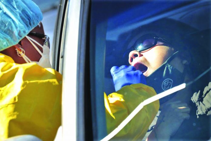 People get tested for COVID-19 at a drive through testing site hosted by the Puente Movement migrant justice organization Saturday, June 20, 2020, in Phoenix.