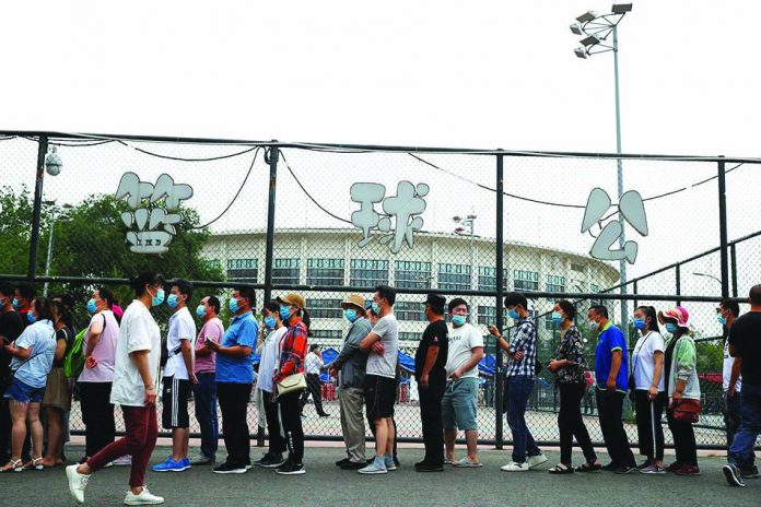 People line up to get a nucleic acid test at a sport center after a spike of cases of the coronavirus disease in Beijing, China, June 17, 2020.