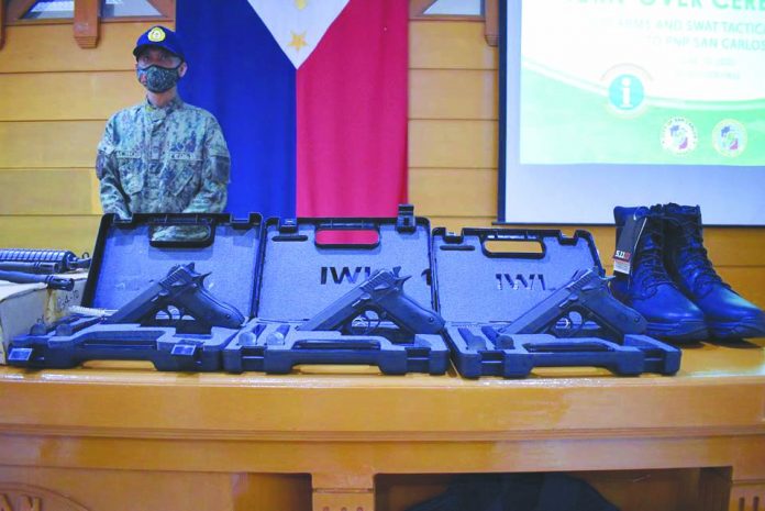 Personnel of the San Carlos City Police in Negros Occidental receive guns and tactical gear, among others, from the city government on June 10.