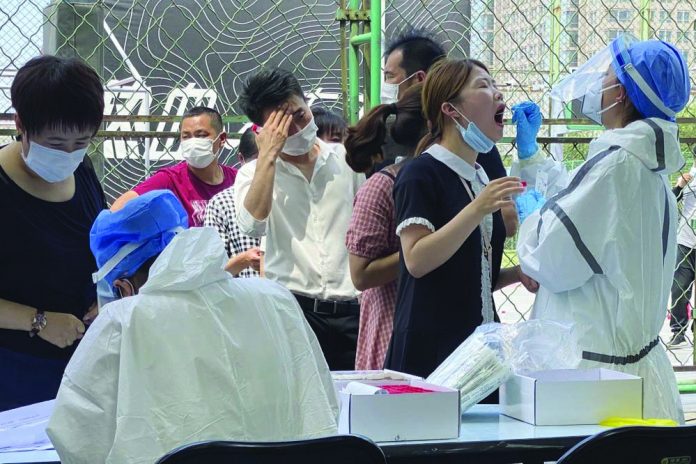 Residents line up to get tested at a coronavirus testing center set up outside a sports facility in Beijing, Tuesday, June 16, 2020.