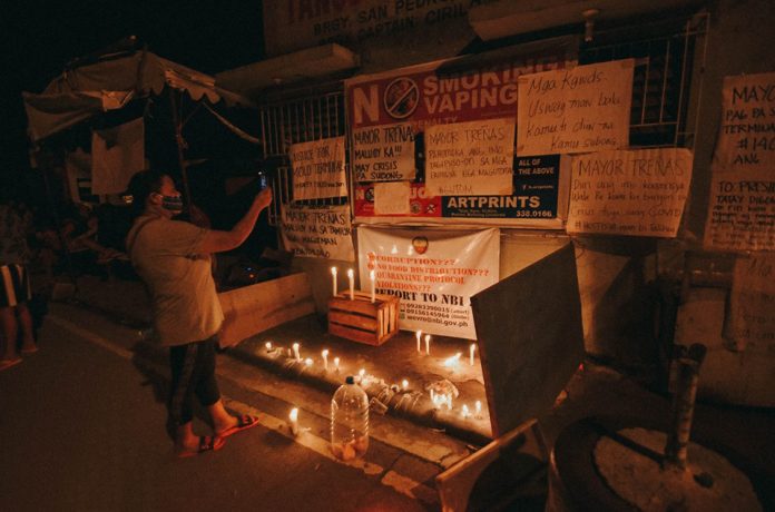 Vendors, dispatchers and stall owners hold a candlelight vigil Thursday night in front of San Pedro Molo public utility vehicle Terminal in Iloilo City's Molo district.