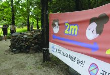 South Korea to let fans watch sports live again A banner about precautions against the coronavirus disease is displayed at a park in Goyang, South Korea yesterday. The banner reads: "Wash hands and wear face masks." AP