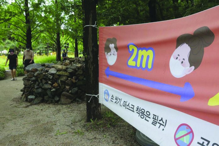 A banner about precautions against the coronavirus disease is displayed at a park in Goyang, South Korea A banner about precautions against the coronavirus disease is displayed at a park in Goyang, South Korea yesterday. The banner reads: "Wash hands and wear face masks." AP