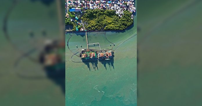 A drone shot shows the power barge where the oil spill in Iloilo City emanated. A drone shot shows the power barge where the oil spill in Iloilo City emanated. Some oil sheen can be seen in the surrounding waters. AC Energy Corp., owner of the power barge, is being pressed to compensate those adversely affected. PHOTO BY AC ENERGY