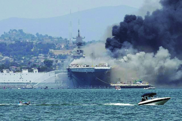 A recreational boat pulls a person on an inner tube on San Diego Bay in California, USA as firefighting boats spray water onto the US Navy amphibious assault ship USS Bonhomme Richard on July 12 A recreational boat pulls a person on an inner tube on San Diego Bay in California, USA as firefighting boats spray water onto the US Navy amphibious assault ship USS Bonhomme Richard on July 12, 2020. Fire broke out onboard the ship. At least 21 sailors were hurt. REUTERS