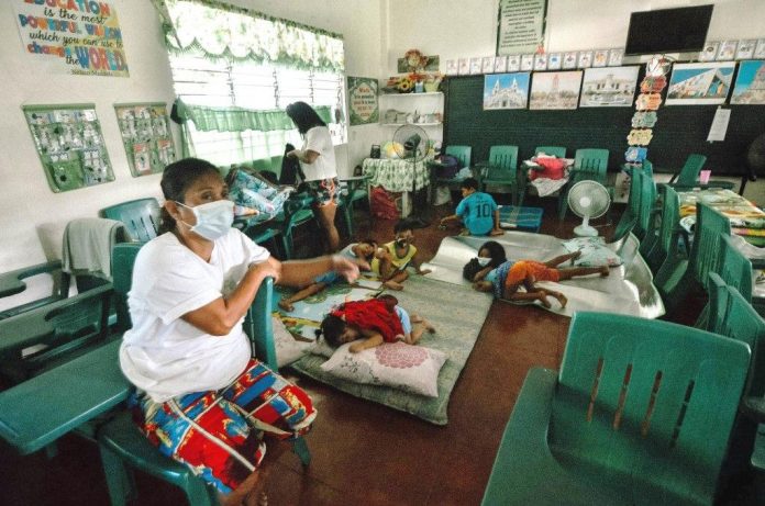 An oil spill-displaced family occupies a classroom at Bo. Obrero Elementary School in Iloilo City. An oil spill-displaced family occupies a classroom at Bo. Obrero Elementary School in Iloilo City. Over 300 village residents have left their houses to avoid the unpleasant smell of bunker oil that spilled out of a power barge after an explosion on July 3, 2020 in Bo. Obrero, Lapuz, Iloilo City. IAN PAUL CORDERO/PN