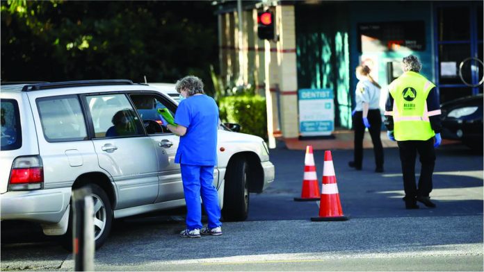 Car passengers wait for COVID-19 tests in Auckland in mid-June after two people returning to New Zealand tested positive. A review has found the country’s managed isolation and quarantine facilities are under ‘extreme stress.’ GETTY IMAGES