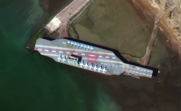 In this Feb. 15, satellite photo provided on July 27 by Maxar Technologies, a mockup aircraft carrier built by Iran is seen at Bandar Abbas, Iran, before being put to sea. In this Feb. 15, satellite photo provided on July 27 by Maxar Technologies, a mockup aircraft carrier built by Iran is seen at Bandar Abbas, Iran, before being put to sea. MAXAR VIA AP