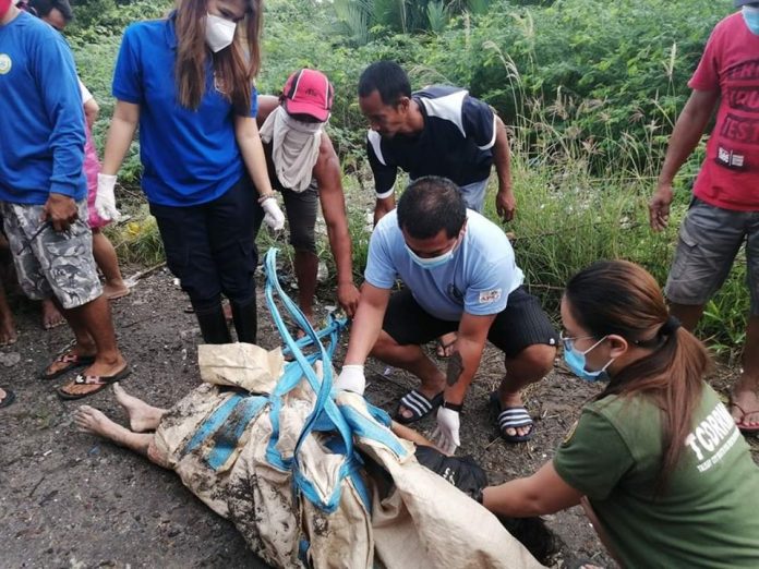 Members of the Talisay City Disaster Risk Reduction Management Office check the lifeless body of 15-year-old Janet Rodriguez. Members of the Talisay City Disaster Risk Reduction Management Office check the lifeless body of 15-year-old Janet Rodriguez. She was swept away by rampaging waters while bathing in the river in Barangay Mandalagan, Bacolod City on July 15, 2020. TALISAY CDRRMO