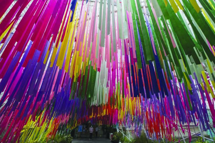 People walk under People walk under colorful ribbons at a same sex charity event in Bangkok, Thursday, July 9, 2020.