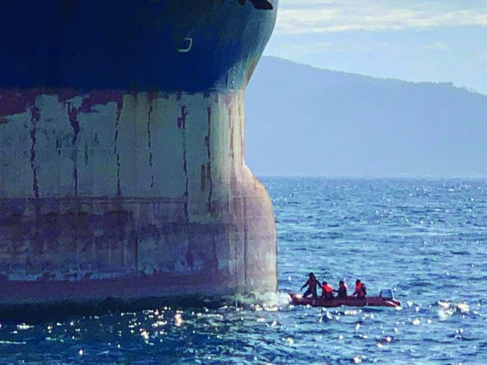 Philippine Coast Guard personnel inspect the bow of the Hong Kong-flagged ship Vienna Wood. PHILIPPINE COAST GUARD