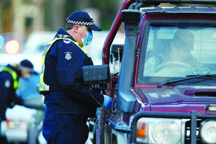 Police stop drivers at a checkpoint, set up in response to the state of Victoria's surge in coronavirus disease cases and resulting suburb lockdowns, in Melbourne, Australia, July 2, 2020.