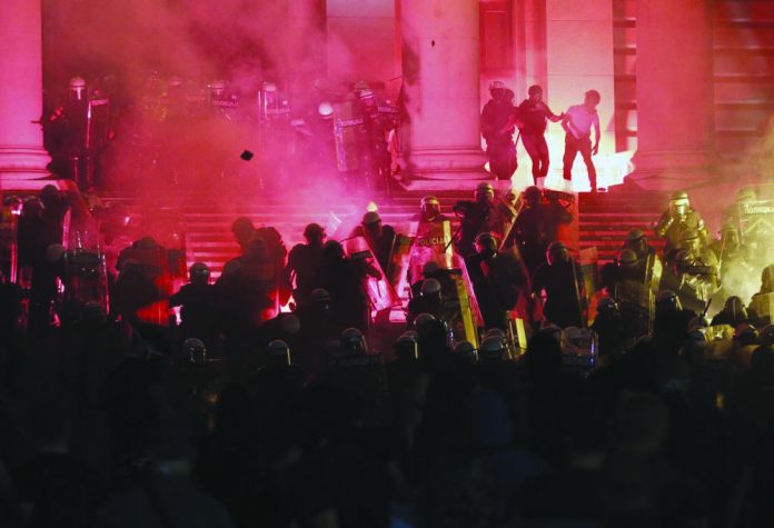 Protesters clash with riot police on the steps of the Serbian parliament during a protest in Belgrade, Serbia, Friday, July 10 2020. Protesters clash with riot police on the steps of the Serbian parliament during a protest in Belgrade, Serbia, Friday, July 10 2020. AP