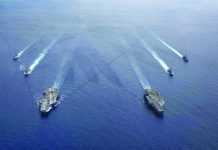 In this photo provided by U.S. Navy, the USS Ronald Reagan and USS Nimitz Carrier Strike Groups steam in formation, in the South China Sea, Monday, July 6, 2020. U.S. NAVY VIA AP