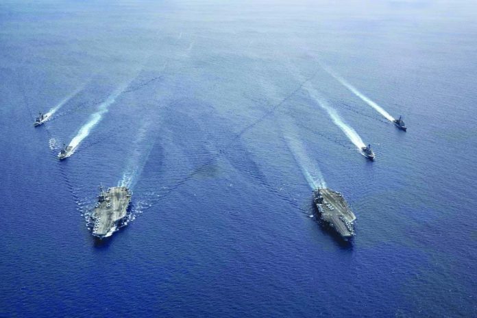 USS Ronald Reagan and USS Nimitz Carrier Strike Groups steam in formation, in the South China Sea, Monday, July 6, 2020. In this photo provided by U.S. Navy, the USS Ronald Reagan and USS Nimitz Carrier Strike Groups steam in formation, in the South China Sea, Monday, July 6, 2020. U.S. NAVY VIA AP