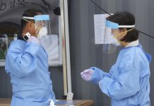 Virus surge makes S. Korea lockdown ‘more likely’ A medical worker measures his own body temperature during the COVID-19 testing at a makeshift clinic in Seoul, South Korea on Aug. 26, 2020. AP