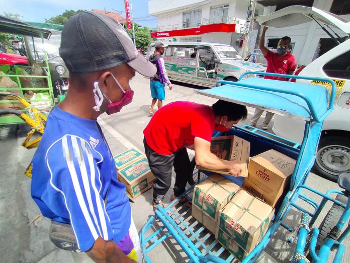 BUYING FRENZY A store personnel loads boxes of alcoholic beverages into this man’s pedicab on Ortiz Street, Iloilo City on Monday, a day before the city government reinstated a two-week prohibition on the sale and consumption of liquor. IAN PAUL CORDERO/PN