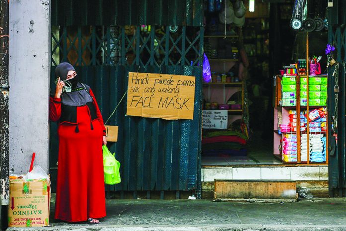 A woman waits for her turn to enter a store in Quinta district in Manila. A woman waits for her turn to enter a store in Quinta district in Manila. ABS-CBN NEWS/FILE