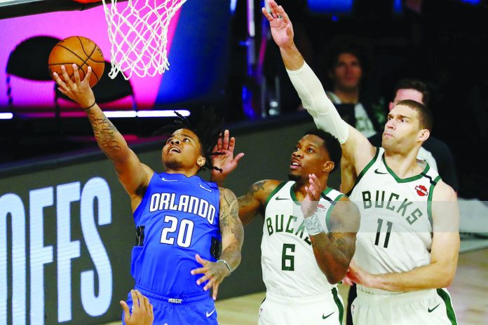 Markelle Fultz #20 of the Orlando Magic shoots in front of Eric Bledsoe #6 and Brook Lopez #11 of the Milwaukee Bucks. GETTY IMAGES